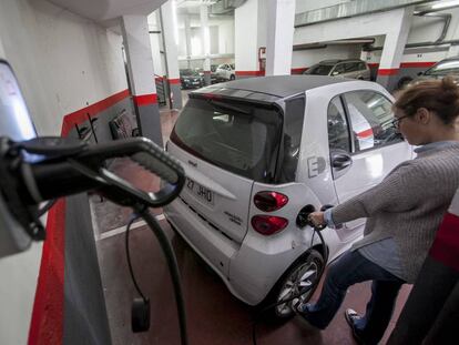 Una usuaria carga el coche en su garaje. 