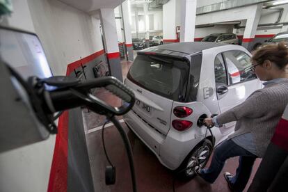 Una usuaria carga el coche en su garaje. 