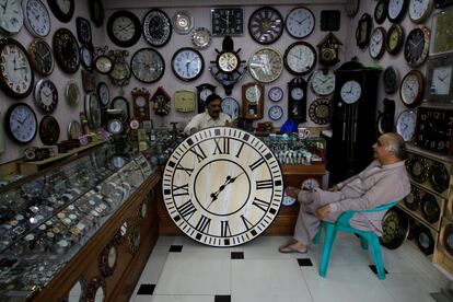 Un relojero habla con un cliente en su tienda en Islamabad, Pakistán.