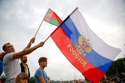 Un hombre sostiene una bandera rusa y otra bielorusa en una manifestación en apyo a Lukashenko, este jueves.
