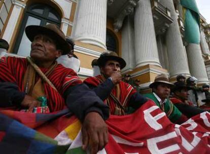 Representantes indígenas sentados a la puerta del edificio del Congreso boliviano para pedir que se apruebe la reforma de Evo Morales.