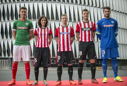 Aymeric Laporte, Iker Muniain, Carlos Gurpegui, Iago Herrerín y la jugadora del equipo femenino Amaia Olabarrieta posan con las nuevas equipaciones para la próxima temporada 2014-2015.