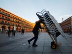 GRAF2618. CÓRDOBA, 17/01/2021.- Un trabajador de la hostelería recoge su terraza de su bar a las seis de la tarde es una de las medias que entran hoy en vigor cierre de toda la hostelería a las seis medidas decretadas por la Junta de Andalucía para controlar la expansión del coronavirus. EFE/Salas