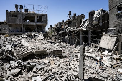 Un niño camina entre los escombros de un edificio destruido por un ataque aéreo antes del alto el fuego alcanzado tras 11 días de conflicto en Magazzi, la Franja de Gaza.