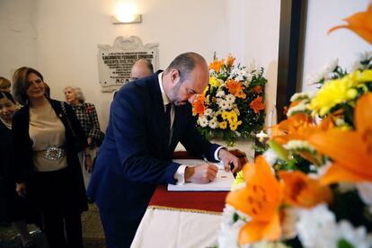 Pedro Rollán, presdiente de la Comunidad de Madrid en funciones, firma el libro de honor durante la tradicional ofrenda floral a los héroes del Dos de Mayo, en el cementerio de La Florida.