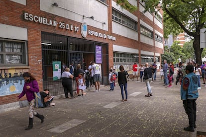 Niños acompañados de sus padres llegan a una escuela primaria en Buenos Aires, Argentina, en febrero de 2021.