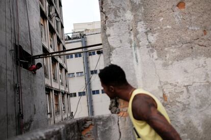 Un residente de la fábrica de textil abandonada, Prestes Maia, ocupada por un movimiento de personas sin hogar, bromea con un niño, en el centro de Sao Paulo, Brasil.