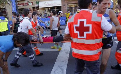 Un corredor de la Behobia-San Sebastián es evacuado en una camilla por las asistencias sanitarias.