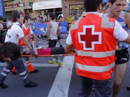 Un corredor de la Behobia-San Sebastián es evacuado en una camilla por las asistencias sanitarias.