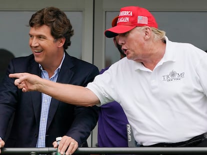 Tucker Carlson y Donald Trump charlan durante un torneo de Golf en julio de 2022.