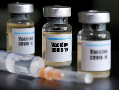 Varias ampollas marcadas como vacuna de covid-19 y una jeringuilla.