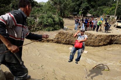 Habitantes cruzan un río mediante una tirolesa tras la afectación de un puente por la tormenta tropical Iota en la comunidad del Redondo del Águila (Honduras).