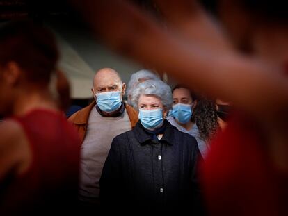 Varias personas caminan con sus mascarillas por Terrassa, este lunes.