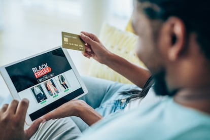 Primer plano de una pareja haciendo compras con una tablet con motivo del Black Friday.