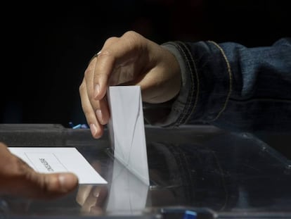 Un votante de Madrid introduce en la urna su voto.