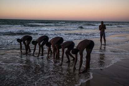 Un grupo de hombres jóvenes se preparan para competir en la playa de Serekunda (Gambia), el 25 de enero.