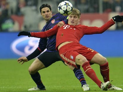 Arteta y Kroos pugnan por un bal&oacute;n.