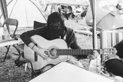 Un chico toca la guitarra en una de las tiendas del 'camping' del Viña Rock.