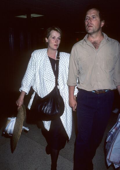 En los años ochenta los looks sobreactuados de las estrellas del Hollywood clásico y las divas de los sesenta y setenta van abriendo paso a estilos más desenfadados y cómodos, mucho más apropiados para viajar largas distancias. El avión como medio de transporte se va desacralizando y se nota en la ropa. Lo prueba este elegante 'outfit' de Meryl Streep, quien llegaba así desde Los Angeles a Nueva York junto a su esposo en 1986. (Photo by Ron Galella, Ltd./Ron Galella Collection via Getty Images)