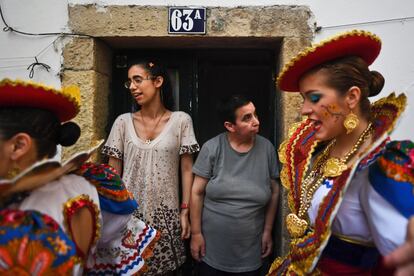 Vecinas del típico barrio lisboeta de Alfama contemplan a dos chicas vestidas con trajes tradicionales antes de asistir al desfile de Santo Antonio de Lisboa. En Alfama, una de las zonas más antiguas de Lisboa, es donde más se vive la festividad.