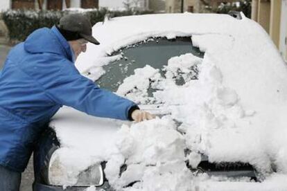 Un conductor retira la nieve de su coche ayer por la mañana en Araia (Álava).