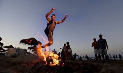Un joven salta una hoguera, como manda la tradición, esta noche en la playa de la Malvarrosa de Valencia.