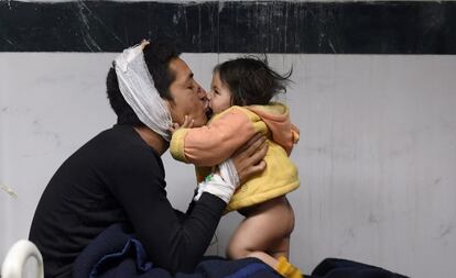 Un padre juega con su hija de ocho meses en el hospital de Katmandú, donde permanece hospitalizado.