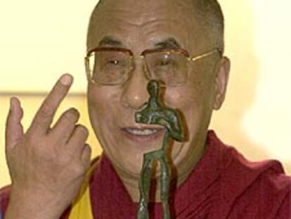 Tenzin Gyatso bromea sobre la estatuilla del premio en la sede del Parlamento Europeo en Madrid.