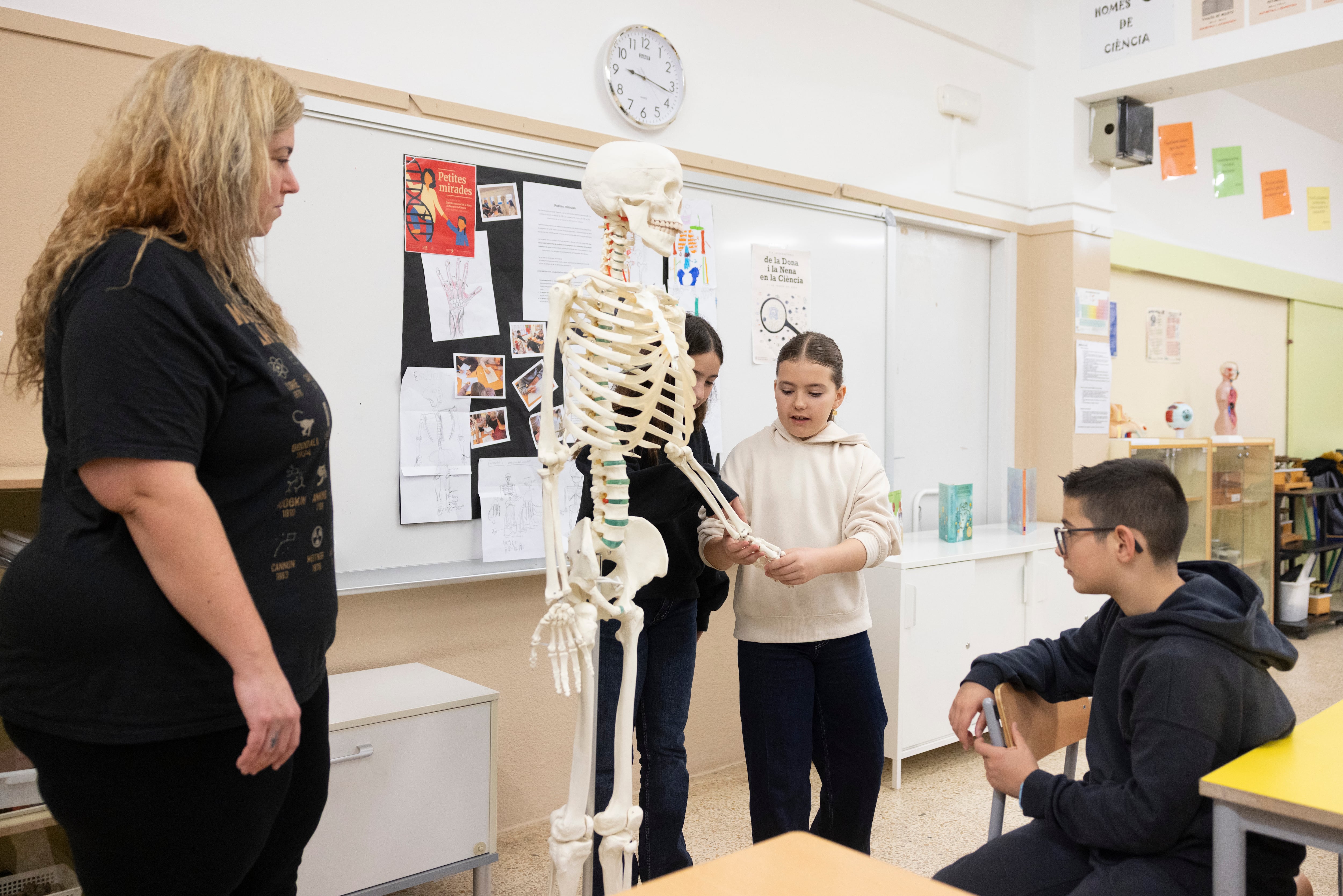 Inés manipula el esqueleto Oscar, bajo la mirada de la investigadora Aroa Casado, el jueves, en el instituto escuela Can Llobet de Barberà del Vallès.