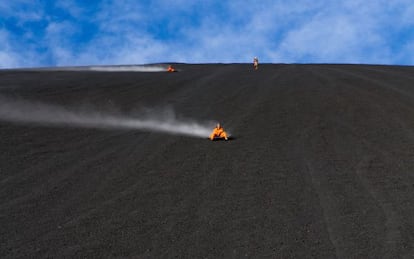 Turistas descendiendo la ladera del volcán Cerro Negro sobre una tabla ('volcanboard'), al noroeste de Nicaragua.