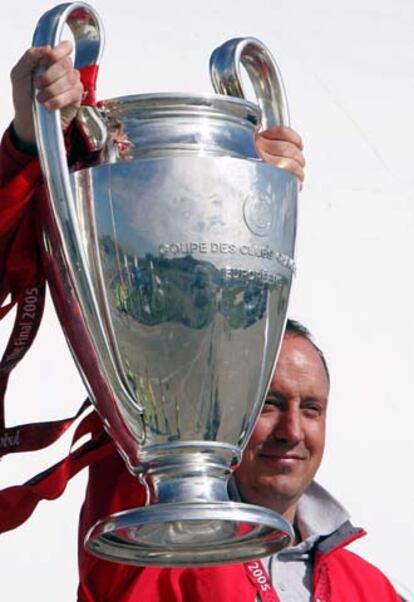 Benítez levanta la copa a su llegada al aeropuerto de Liverpool.