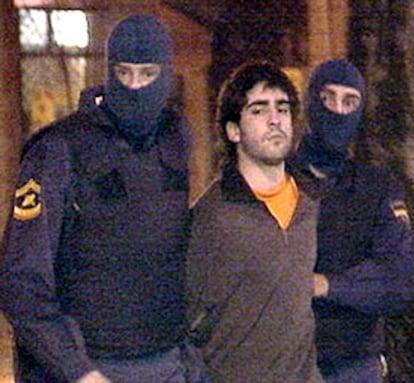 Dos agentes detienen a uno de los presuntos miembros de un grupo de apoyo de ETA en la madrugada de ayer.