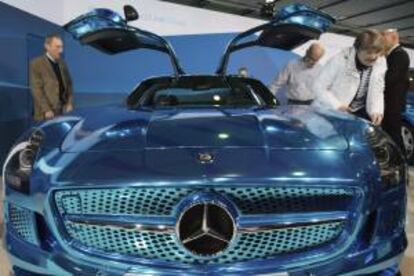 Varios accionistas de Daimler AG observan un Mercedes Benz SLS AMG Electric Drive durante su asistencia a la junta general de accionistas de la compañía celebrada en Berlín (Alemania). EFE/Archivo