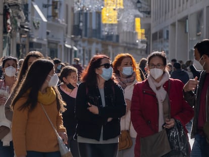 Varios grupos de personas con mascarilla en una calle comercial de Sevilla.