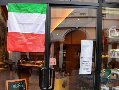 Una bandera italiana a la entrada de una panadería en la ciudad de Albino (Lombardía).