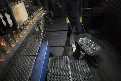 In this Tuesday, Jan. 26, 2016 photo, a worker pushes a wheelbarrow with broken glass bottles at the Phoenicia Glass Works Ltd. factory in the southern Israeli town of Yeruham. Factory workers grind these rejects into shards and pile them outside. Recycled glass bottles from across the country are sent here and ground up, too. The glass pieces are shoveled into the ovens to be fired into new glass bottles. Sand, the basic ingredient of glass, is hauled in from a nearby desert quarry. (AP Photo/Oded Balilty)