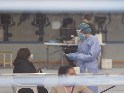 Un trabajador del Sermas realiza un test de antígeno en un polideportivo de Los Rosales, en Villaverde.
