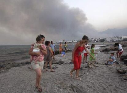 Vecinos de Mojácar abandonan ayer las playas del municipio ante el avance del humo.