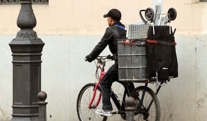 Un recogedor de chatarra circula en su bicicleta por el centro de Valencia.