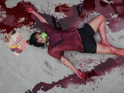 Un activista permanece en el suelo cubierta con sangre ficticia, durante una protesta contra la destrucción del medio ambiente en Yakarta (Indonesia).