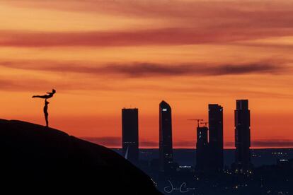 Una pareja de acróbatas con las Cuatro Torres de fondo. Pincha sobre la imagen para ver más fotos de la silueta de estos edificios.