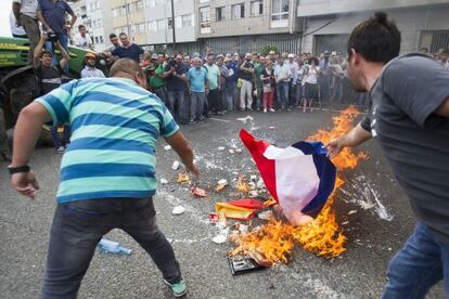 Los ganaderos queman las banderas de Francia y Alemania junto a productos lácteos extranjeros.