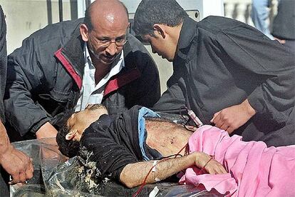 Un hombre malherido es trasladado a un hospital tras el atentado contra la mezquita de Kadhmain.