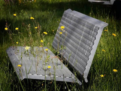 Un banc en un parc infantil, envaït per la vegetació a causa del confinament.