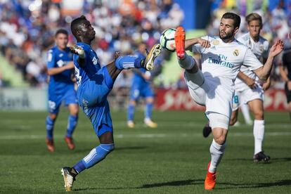 El delantero del Getafe Ndiaye disputa un balón con el defensa del Real Madrid Nacho Fernández.