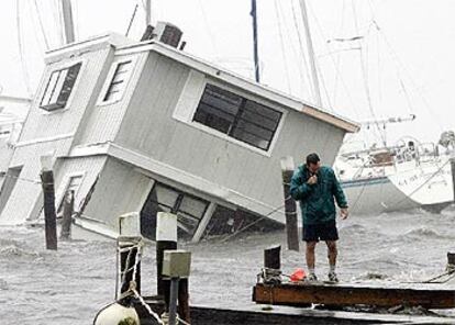 Un hombre observa su embarcación hundida en un muelle de Titusville, en el Estado de Florida.