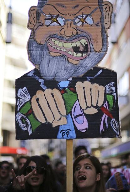 Una joven protesta con una caricatura del presidente del gobierno español Mariano Rajoy durante la huelga general del 14-N en Pontevedra