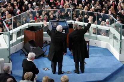 Bush (derecha) saluda junto al vicepresidente Dick Cheney tras jurar el cargo.
