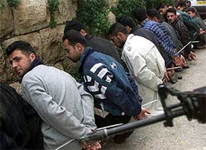 Palestinos detenidos bajo vigilancia de tropas israelíes.