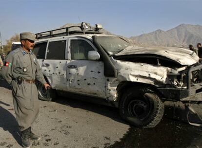 Un policía afgano, junto  al vehículo de la Embajada alemana atacado por un terrorista en Kabul.